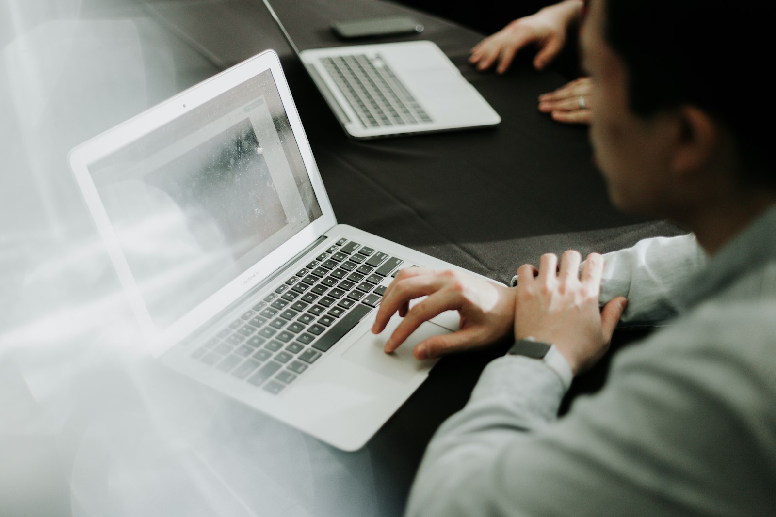A man working alone at a laptop in an office.